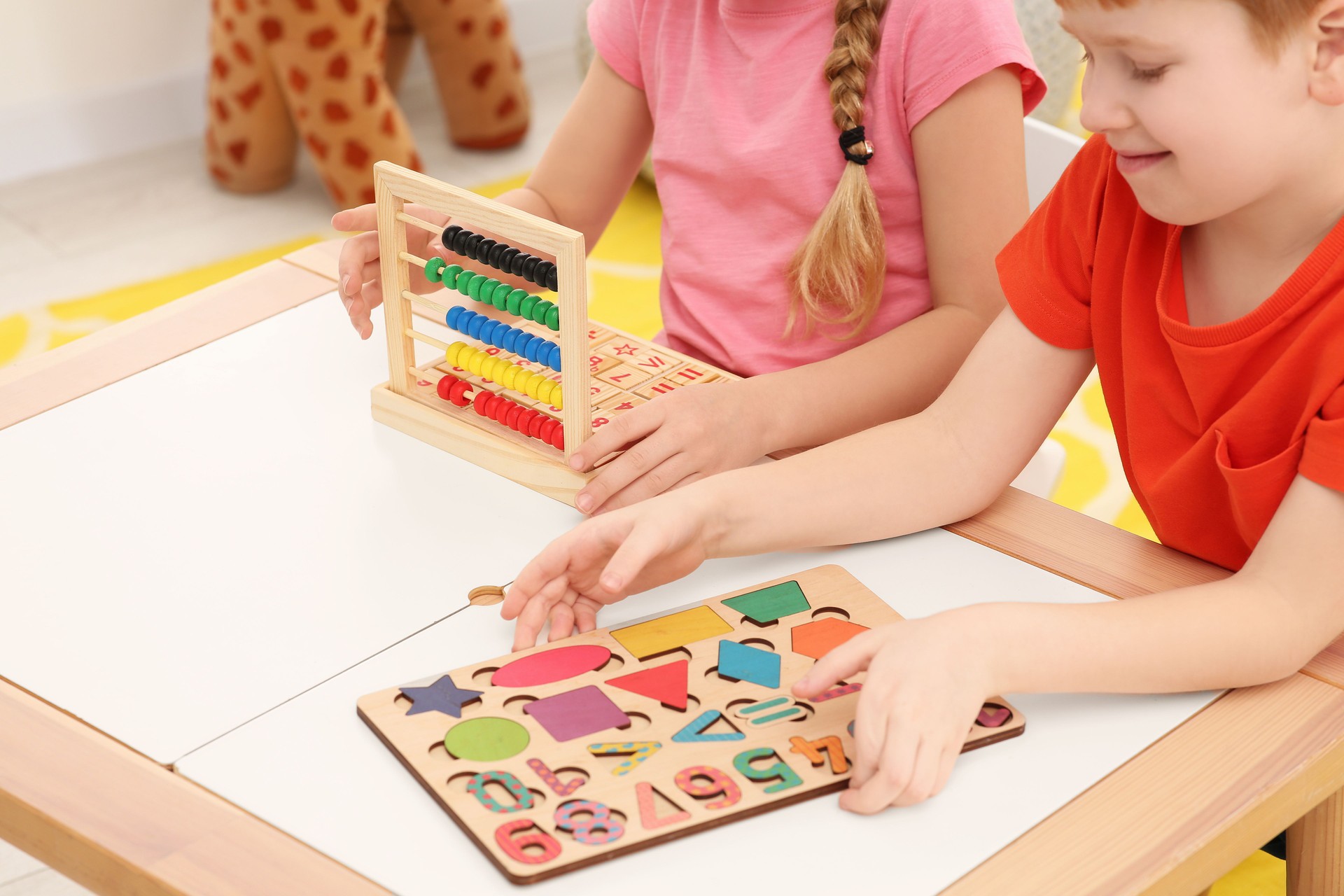 Children playing with different math game kits at desk indoors, closeup. Study mathematics with pleasure